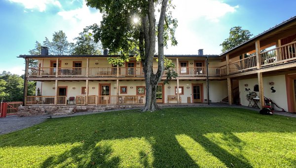 Grüner Innenhof umrahmt vom 2-stöckigen Haus mit Balkonen