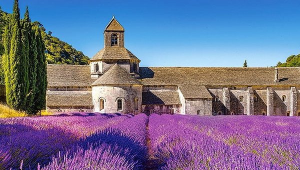 Ein Gebäude aus Stein mit Lavendel im Vordergrund